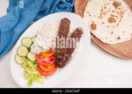 Une dose de pain plat délicieux envelopper le koobideh avec des légumes frais et de la sauce tzatziki Banque D'Images