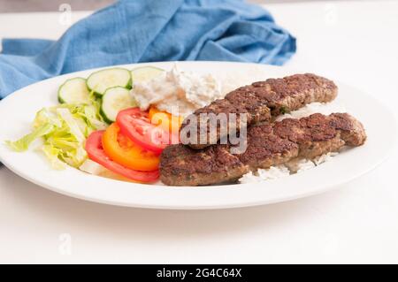 Un délicieux pain plat envelopper le koobideh avec des légumes frais et de la sauce tzatziki Banque D'Images