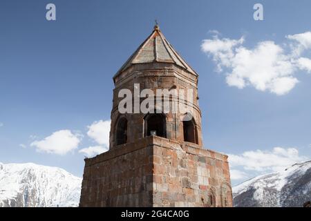 L'église de la Trinité de Gergeti est sous ciel nuageux par une journée ensoleillée, le Mont Kazbek, Géorgie Banque D'Images