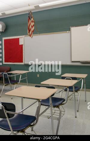 Salle de classe avec bureaux, chaises, drapeau et tableau blanc. Banque D'Images