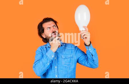 Homme pensif avec grande lampe. Homme de pensée barbu avec ampoule. Nouveau générateur d'idées. Économie d'énergie. Banque D'Images