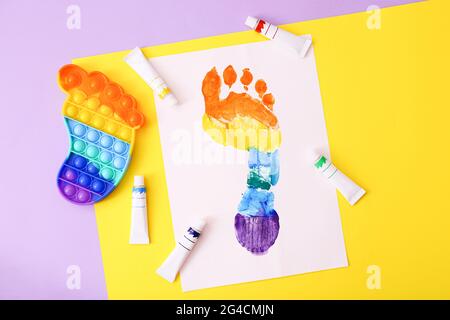 Nouveau jeu tendance en silicone coloré anti stress Pop IT pour enfant et empreinte colorée sur fond coloré. Banque D'Images