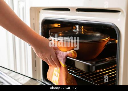 fermez les mains de la femme et ouvrez le four et sortez les aliments frais cuits à la maison Banque D'Images