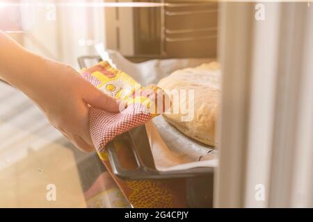 fermez les mains de la femme et ouvrez le four et sortez les aliments frais cuits à la maison Banque D'Images