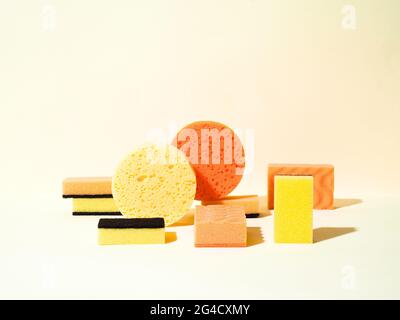 Éponges en caoutchouc mousse de différentes formes. Formes rondes et rectangulaires. Couleurs jaune et orange. Concept de nettoyage. Composition géométrique. Banque D'Images