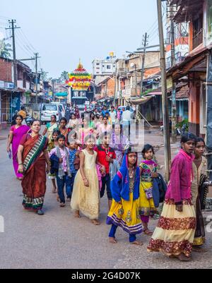 De jeunes écoliers indiens portant des vêtements colorés marchent en grand groupe dans la rue, Gokarna, Karnataka, Inde Banque D'Images