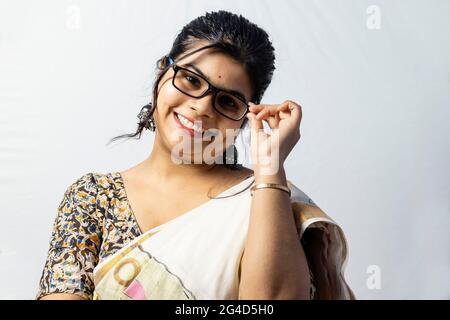 Isolé sur fond blanc une femme de bureau indienne en saree posant avec ses lunettes Banque D'Images