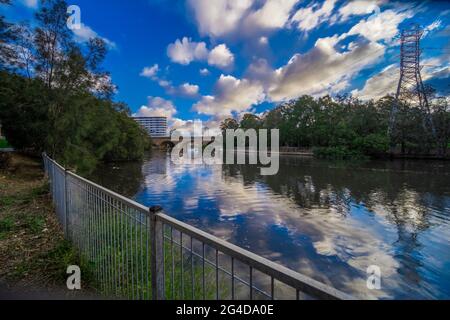 Cuisine la rivière à Canterbury Sydney Australie lors d'un magnifique coucher de soleil après-midi. Des nuages doux et moelleux reflétant des arbres luxuriants et verts Banque D'Images