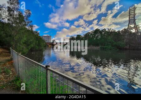 Cuisine la rivière à Canterbury Sydney Australie lors d'un magnifique coucher de soleil après-midi. Des nuages doux et moelleux reflétant des arbres luxuriants et verts Banque D'Images