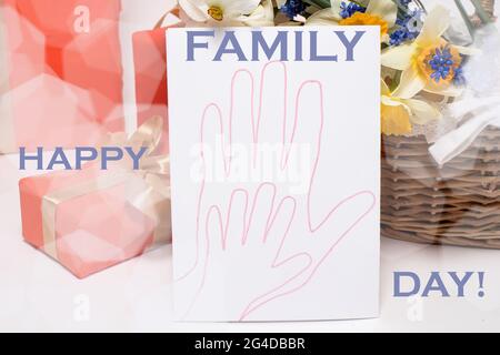 Belle carte pour enfants avec la main d'un parent adulte d'une mère ou d'un père et d'un enfant avec une inscription Happy Family Day. Banque D'Images