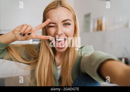 Gros plan d'une jolie femme souriante faisant un selfie à l'intérieur Banque D'Images