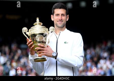 Photo du dossier datée du 14-07-2019 de Novak Djokovic avec le trophée après avoir battu Roger Federer dans la finale des singles pour hommes le treize jour des Championnats de Wimbledon au All England Lawn tennis and Croquet Club, Wimbledon. Date de publication : lundi 21 juin 2021. Banque D'Images