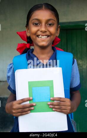 Souriant Indian Rural School fille tenant le carnet à l'école Banque D'Images