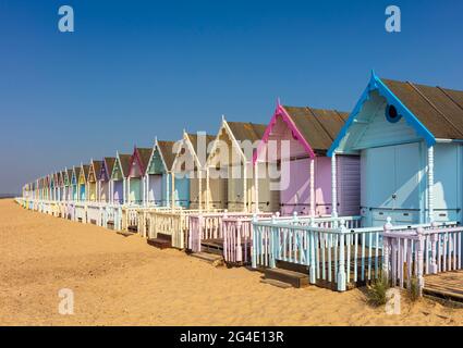 Cabines de plage aux couleurs pastel, Mersea Island, Essex, Royaume-Uni. Banque D'Images