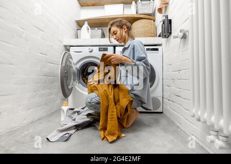 Femme lavant des vêtements à la maison Banque D'Images