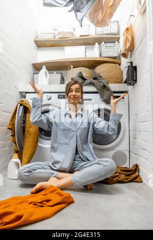 Femme de ménage jetant des vêtements à la blanchisserie Banque D'Images