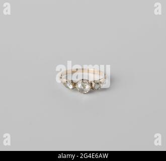 Anneau avec diamants. Bague avec trois diamants roses. Un grand diamant rond entre deux un peu ovales. Banque D'Images