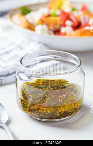 Vinaigrette à la moutarde, à l'huile d'olive et à l'aneth dans un pot en verre. Cuisine saine concept. Banque D'Images