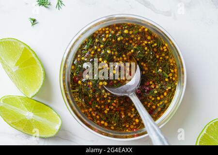 Vinaigrette à la moutarde, à l'huile d'olive et à l'aneth dans un pot en verre, vue de dessus. Cuisine saine concept. Banque D'Images
