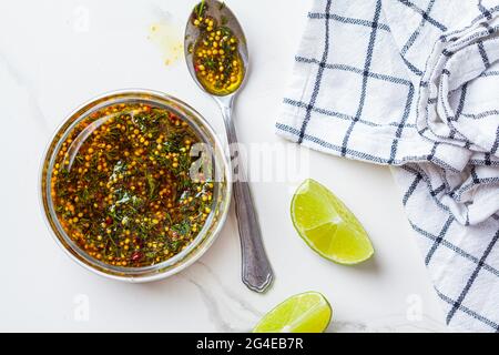 Vinaigrette à la moutarde, à l'huile d'olive et à l'aneth dans un pot en verre, vue de dessus. Cuisine saine concept. Banque D'Images