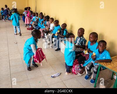 MBOUR, SÉNÉGAL - JANVIER CIRCA, 2021. Petits enfants noirs mignons non identifiés les enfants avec des uniformes sont assis sur un banc dans leur école primaire. Vin Banque D'Images