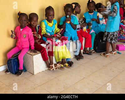 MBOUR, SÉNÉGAL - JANVIER CIRCA, 2021. Petits enfants noirs mignons non identifiés les enfants avec des uniformes sont assis sur un banc dans leur école primaire. Vin Banque D'Images