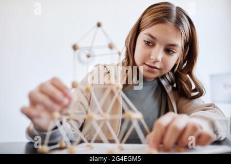 Portrait d'une jeune fille qui fait des modèles tout en appréciant la classe d'art et d'artisanat à l'école Banque D'Images