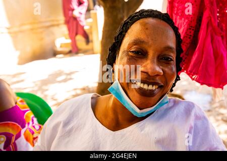 MBOUR, SÉNÉGAL - JANVIER CIRCA, 2021. sénégalaise non identifiée jolie femme mûre en robe traditionnelle en plein air regardant sourire. Pauvreté et bonheur Banque D'Images