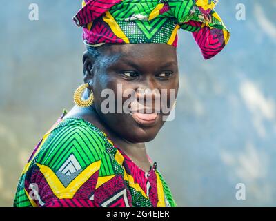 MBOUR, SÉNÉGAL - JANVIER CIRCA, 2021. sénégalaise non identifiée jolie femme mûre en robe traditionnelle en plein air regardant sourire. Pauvreté et bonheur Banque D'Images