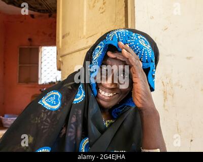 MBOUR, SÉNÉGAL - JANVIER CIRCA, 2021. sénégalaise non identifiée jolie femme mûre en robe traditionnelle en plein air regardant sourire. Pauvreté et bonheur Banque D'Images