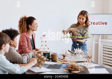 Portrait d'une jeune fille présentant le projet scolaire à la classe pendant la leçon d'art et d'artisanat à l'école Banque D'Images