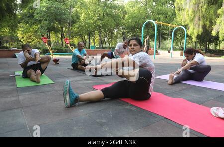 New Delhi, Inde. 21 juin 2021. Les femmes indiennes exécutent la pose Archer (Akarna Danurasana), postures de yoga pour marquer la Journée internationale de yoga pendant la pandémie du coronavirus au District Park.la Journée du yoga est célébrée partout dans le monde pour souligner l'importance du yoga et aider à garder notre corps et notre esprit en bonne santé. Le Yoga international a été célébré chaque année le 21 juin, après sa création à l'Assemblée générale des Nations Unies en 2014. Le thème de la Journée internationale du Yoga 2021 est décidé par le Yoga de l'ONU pour le bien-être. Crédit : SOPA Images Limited/Alamy Live News Banque D'Images