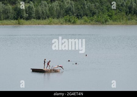 Pirna, Allemagne. 21 juin 2021. Les baigneurs se trouvent sur une île de baignade dans le lac de baignade de Birkwitz. En raison de plusieurs accidents mortels survenus récemment dans les rivières et les lacs, l'Association allemande pour le sauvetage des personnes (DLRG) met en garde contre les risques de nager dans ces eaux. Credit: Sebastian Kahnert/dpa-Zentralbild/dpa - ATTENTION: Utiliser seulement en format complet/dpa/Alamy Live News Banque D'Images