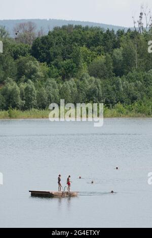 Pirna, Allemagne. 21 juin 2021. Les baigneurs se trouvent sur une île de baignade dans le lac de baignade de Birkwitz. En raison de plusieurs accidents mortels survenus récemment dans les rivières et les lacs, l'Association allemande pour le sauvetage des personnes (DLRG) met en garde contre les risques de nager dans ces eaux. Credit: Sebastian Kahnert/dpa-Zentralbild/dpa/Alay Live News Banque D'Images