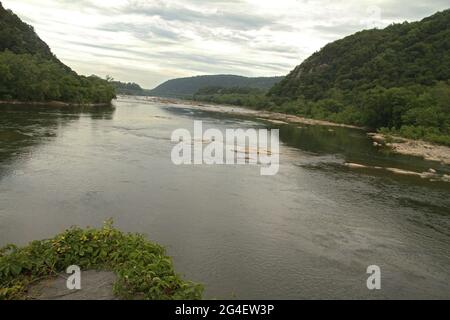 Harpers Ferry, WV, États-Unis. Rivière Potomac qui coule entre ma et va, après la confluence avec la rivière Shenandoah. Sandy Hook Bridge vu au loin. Banque D'Images