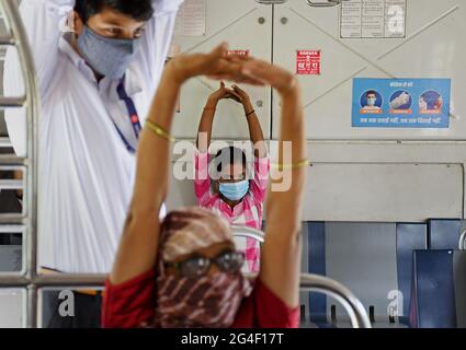 Mumbai, Inde. 21 juin 2021. Les gens portant des masques faciaux comme mesure de précaution contre la propagation de covid-19 pratiquer l'exercice de yoga à l'intérieur d'un train local à Mumbai.la Journée internationale de yoga est célébrée dans le monde entier le 21 juin chaque année. (Photo par Ashish Vaishnav/SOPA Images/Sipa USA) crédit: SIPA USA/Alay Live News Banque D'Images