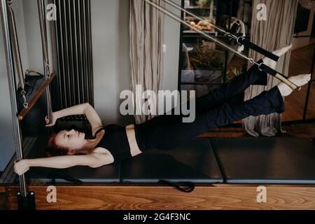 Jeune femme travaillant dur sur les pilates reformer Banque D'Images