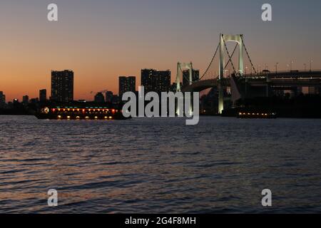 Vue depuis la plage d'Odaiba à Tokyo Bay avec Rainbow Bridge at Dusk, Tokyo, Japon Banque D'Images