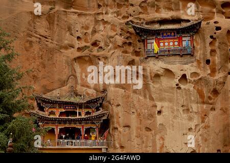 Les touristes visitent les grottes du Temple Mati près de Wangye, dans le nord-ouest de la province de Gansu, le samedi 19 juin 2021. L'ancien temple, également connu sous le nom de Temple du Hoof du cheval, est un site bouddhiste tibétain protégé avec plus de 70 grottes sculptées à la main dans la falaise. Selon la légende, Pegasus chinois a une fois atterri sur la falaise et a laissé une marque sur elle, et ainsi le temple a obtenu son nom. Le tourisme dans la province de Gansu, le septième plus grand district administratif de Chine, représente près de la moitié des revenus annuels de la province tout en restant l'une des provinces les plus pauvres du pays. Photo de Stephen Shaver/UPI Banque D'Images