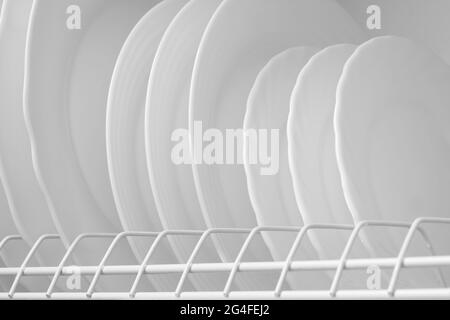 Nettoyez les plaques blanches sur le égouttoir à vaisselle après le lavage Banque D'Images