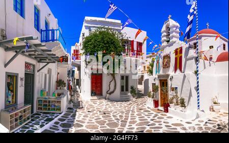 Authentique Grèce traditionnelle. Charmantes rues fleuries colorées de l'île de Mykonos avec boutiques de mode et petites églises. Cyclades juin 2021 Banque D'Images