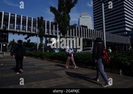 Au milieu de la menace d'une augmentation des cas de Covid-19 dans la région de la capitale spéciale de Jakarta, un certain nombre de travailleurs portant des masques se sont dirigés vers leurs bureaux dans la zone de bureaux de Jalan Thamrin, dans le centre de Jakarta, en Indonésie, le lundi 21 juin, 2021. Les décès dus à Covid-19 à Jakarta ont de nouveau augmenté. Il est demandé aux habitants de la région de la capitale spéciale de Jakarta de continuer à faire preuve de vigilance face au taux d'ajout des cas Covid-19. Aujourd'hui, le nombre total de cas en Indonésie a atteint 2 millions de cas, la région de la capitale spéciale de Jakarta qui est toujours le centre de la propagation du Banque D'Images