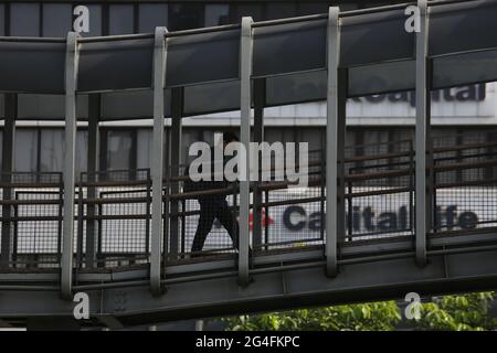 Au milieu de la menace d'une augmentation des cas de Covid-19 dans la région de la capitale spéciale de Jakarta, un travailleur portant un masque se rend à son bureau dans la zone du bureau de rue Thamrin, dans le centre de Jakarta, en Indonésie, le lundi 21 juin, 2021. Les décès dus à Covid-19 à Jakarta ont de nouveau augmenté. Il est demandé aux habitants de la région de la capitale spéciale de Jakarta de continuer à faire preuve de vigilance face au taux d'ajout des cas Covid-19. Aujourd'hui, le nombre total de cas en Indonésie a atteint 2 millions de cas, la région de la capitale spéciale de Jakarta, qui est toujours le centre de la propagation du virus. (Photo Banque D'Images