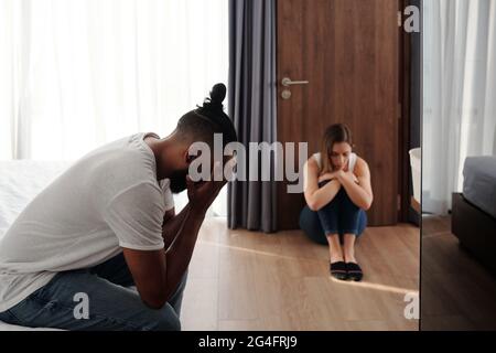 Malheureux offensé mari et femme assis dans la chambre à coucher à part l'un de l'autre après grand querelle ou combat, divorce et les problèmes de relation concept Banque D'Images