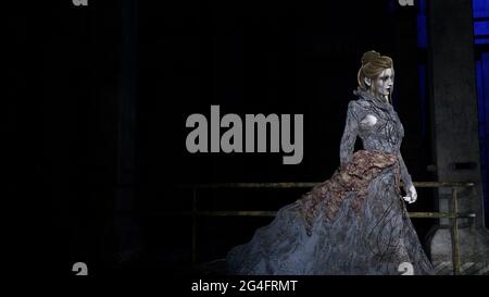 illustration 3d d'une femme pâle portant une longue robe de gloude fluide marchant dans un environnement sombre et sinistre. Banque D'Images