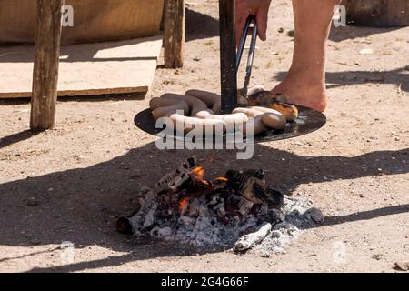 Auning, Danemark - 19 juin 2021 : les gens du XVIIIe siècle chauffent des saucisses et les vendent sur le marché Banque D'Images