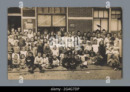 Portrait de groupe d'enfants et de femmes inconnues pour une épicerie (vraisemblablement) à Westzaan. . Banque D'Images