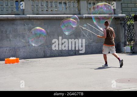 Homme faisant de la bulle de savon sur la promenade de la ville de Zug en Suisse. Banque D'Images