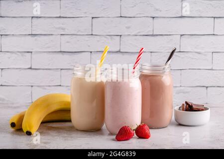 Ensemble de milkshakes à la fraise et au chocolat dans les pots en verre Banque D'Images