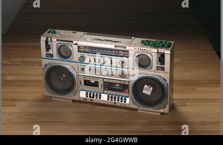 Une boombox tecsonique avec une couverture métallique marron clair utilisée par public Enemy. La boombox est dotée d'une poignée au sommet, d'une antenne télescopique, de six haut-parleurs, d'une radio, d'un lecteur de cassettes double et de plusieurs commandes. Il y a des autocollants d'ennemi public verts et noirs collés autour des côtés gauche, supérieur et droit. Il y a un autocollant de chaque côté et trois sur le dessus. Tous les autocollants présentent des degrés de perte variables. Deux compartiments de cassette marqués « MÉTAL / récepteur STÉRÉO 4 BANDES / LECTEUR DE DOUBLE CASSETTE » et « ÉGALISEUR GRAPHIQUE 5 BANDES MX-900 ». Le grand haut-parleur rond en bas à droite Banque D'Images